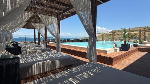 a resort with a swimming pool with beds and a swimming pool at Ferush Boutique Hotel in Urla