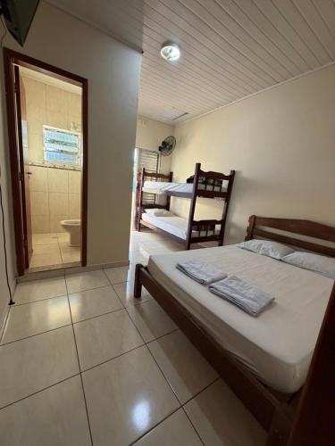 a bedroom with a bed and a bathroom with a shower at Pousada Flor do Vale in São José dos Campos