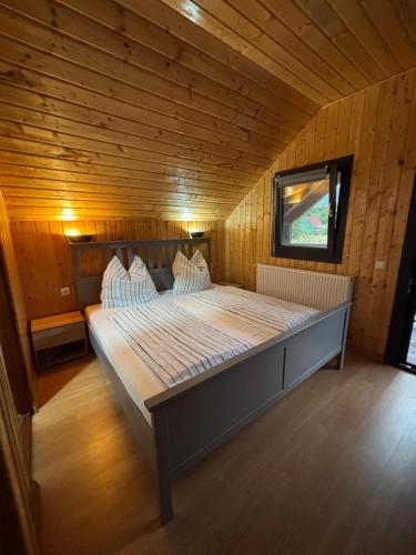 a bedroom with a large bed in a wooden room at Bergblick in Arpaşu de Sus