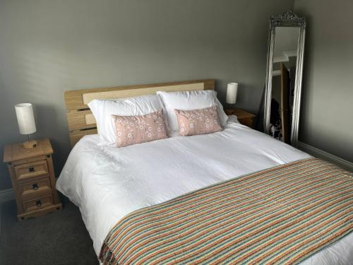 a bedroom with a large bed with pillows and a mirror at Shepherd's Lodge in Skipton