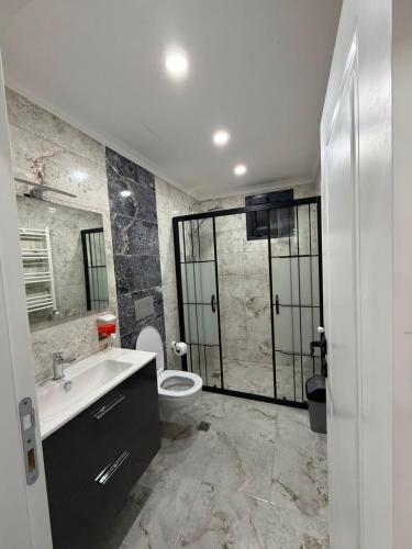 a bathroom with a toilet and a sink and a shower at Atlas Suite Trabzon in Trabzon