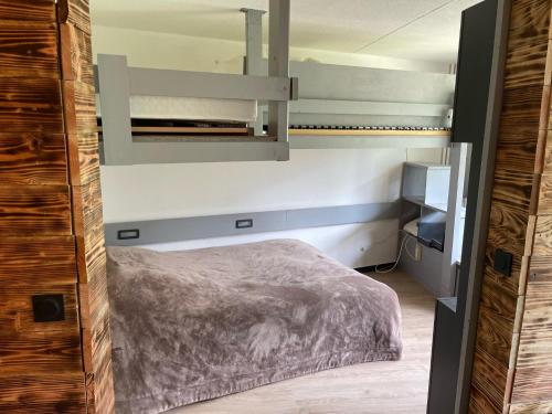 a small bedroom with a bed and a mirror at Panorama à La Mongie in La Mongie