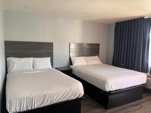 a hotel room with two beds and a window at Travel Inn Gilroy in Gilroy