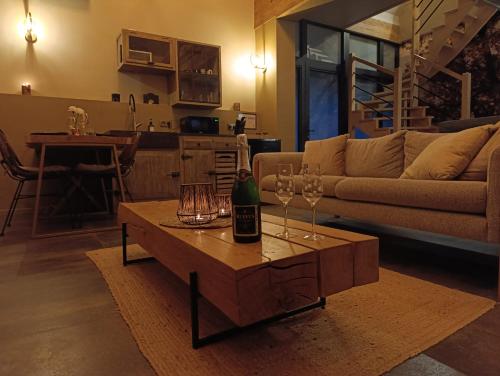 a living room with a bottle of wine on a table at Terra Serena in Frasnes-lez-Anvaing