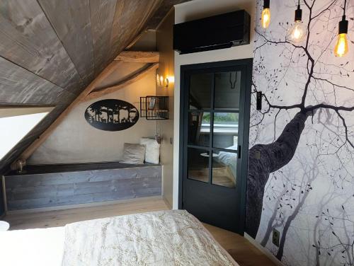 a bedroom with a tree mural on the wall at Terra Serena in Frasnes-lez-Anvaing