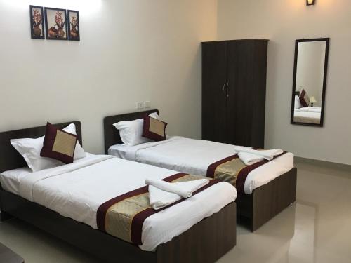 two beds in a room with a mirror at Sun Shine in Chennai