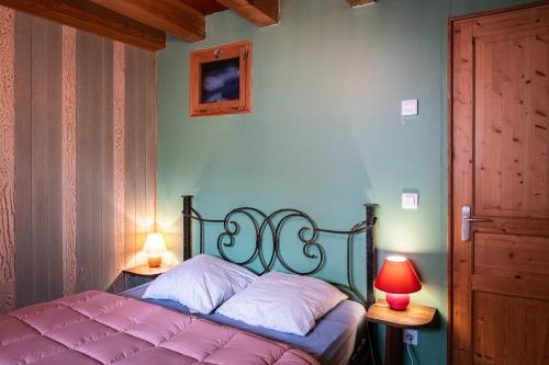 a bed in a bedroom with two lamps and a door at la bergerie in Mialanes