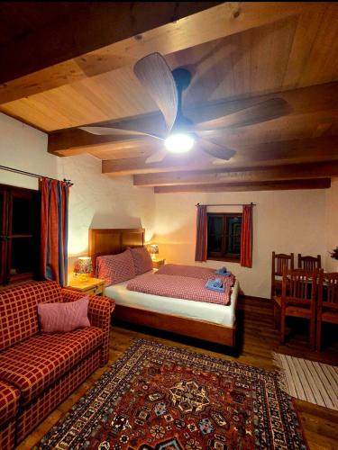 a bedroom with a large bed and a couch at Sonnleit'n Zimmer 6 in Abtenau