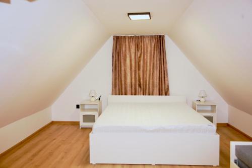 a bedroom with a white bed and a window at Officium P47 in Rakamaz
