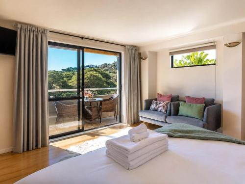 a living room with a large window and a couch at Aqua Sands #1 - Stay Waiheke in Oneroa