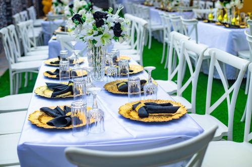 a white table with plates of food and flowers on it at EdJames Lodge in Ashaiman
