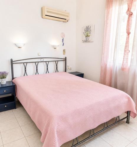 a bedroom with a bed with a pink blanket on it at Louis' apartment with view in Gythio