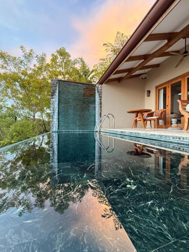 a house with a swimming pool and a patio at Casa Chameleon Hotel Las Catalinas - Adults Only in Playa Flamingo