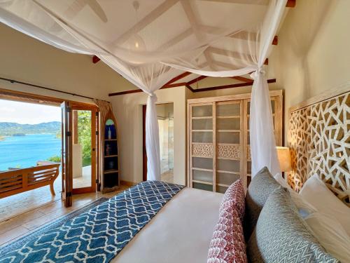 a bedroom with a bed with a view of the ocean at Casa Chameleon Hotel Las Catalinas - Adults Only in Playa Flamingo