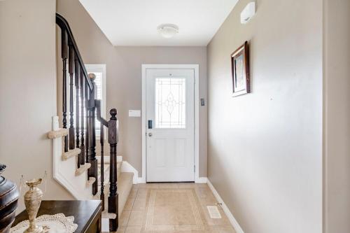 a hallway with a white door and a wooden floor at Nimo Homestay in Guelph