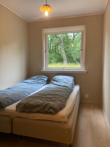 two beds in a room with a window at Appartment in Jørpeland
