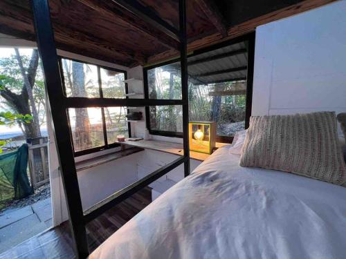 a bedroom with a bed and a large window at Private Beachfront Beach Hut in Manzanillo