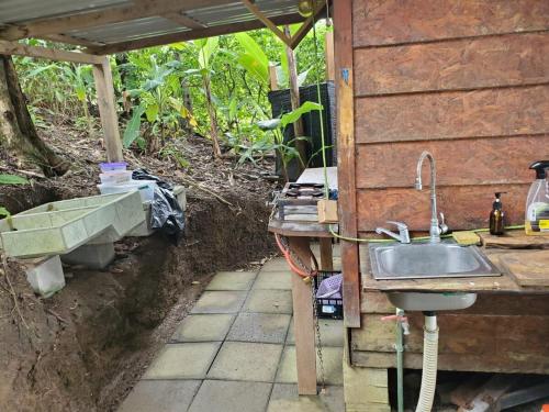 a kitchen with a sink and a table with a tub at Private Beachfront Beach Hut in Manzanillo