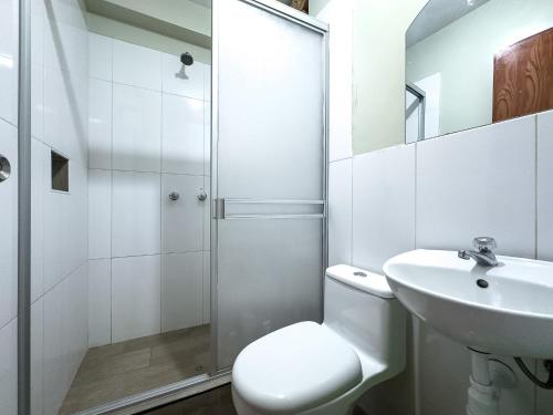 a bathroom with a shower and a toilet and a sink at Hotel Qoyllur urcos in Urcos