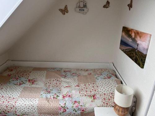 a bedroom with a bed with a quilt on it at Ferienwohnung Möwenschiss - Haus Bake in Büsum