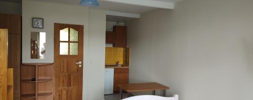 a kitchen with a wooden door and a table at Willa Madi in Grzybowo