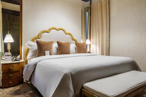a bedroom with a large white bed and a mirror at Hotel Boutique Santo Toribio in Cartagena de Indias