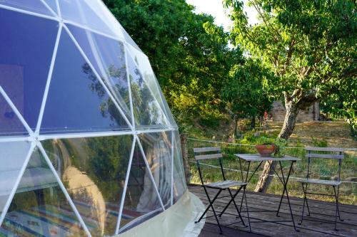 a igloo sitting on a deck with a table and chairs at glamping giardino museo a gisa in Petralia Sottana