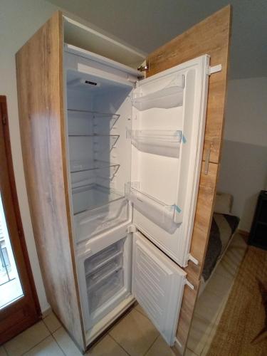 an empty refrigerator with its door open in a kitchen at U muntagna Olmo in Olmo