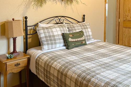 a bed with a green pillow and a lamp on a table at Breathtaking Mtn & Lake Views! Glacier Country Gem in Dayton