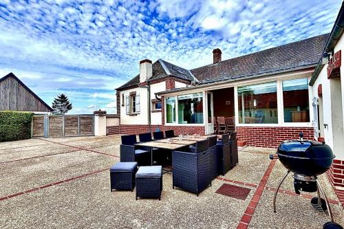 a house with a grill and chairs in a yard at Maison de charme - Jardin - BBQ - 10min du Crotoy in Rue