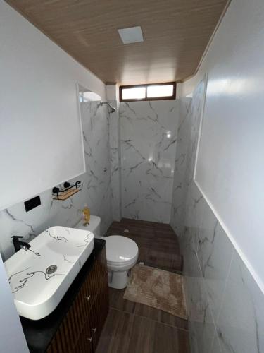 a bathroom with a white sink and a toilet at Casa playera in Crucita