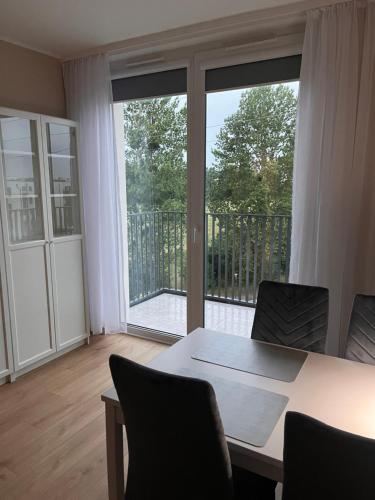 a room with a table and chairs and a large window at Royal Apartment in Rumia