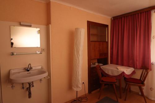 a bathroom with a sink and a table and a window at Ferienhaus Rieger in Mallnitz