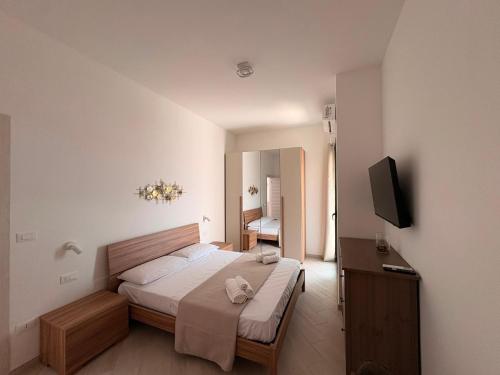 a bedroom with a bed and a flat screen tv at MESSAPIA HOME Apartments in Mesagne