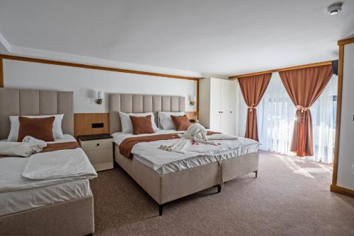 a hotel room with two beds and a large window at Vila Hera Spa in Vrbas