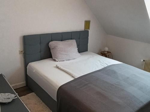 a bed with a blue headboard in a bedroom at Manjana`s Waldblick in Braunlage