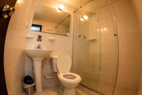 a bathroom with a shower and a toilet and a sink at House Studio Hotel in Bogotá