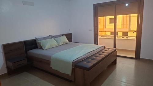 a bedroom with a large bed with a bench at Villa Sereine in Sidi Yahia