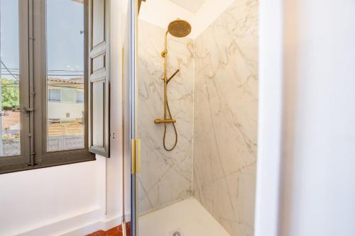 a shower in a bathroom with a window at Maison Aimé in La Motte