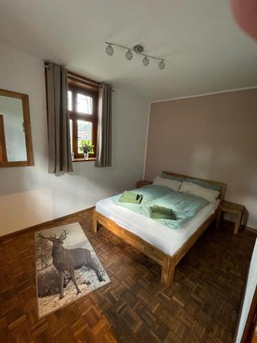 a bedroom with a bed and a picture of a deer at Jagdstube in Prezelle