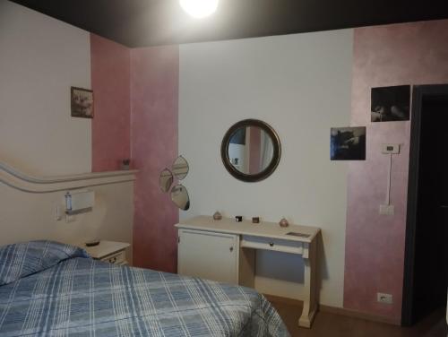 a bedroom with a bed and a sink and a mirror at Casa TERESINA in Ardenno