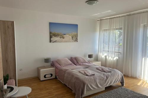 a bedroom with a bed with pink pillows on it at Apartment in Dabrowa near the Sea in Gostyniec