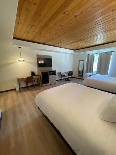 a bedroom with a large white bed and a desk at The Coolin Motel in Coolin