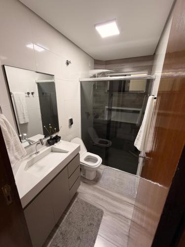 a bathroom with a sink and a toilet and a shower at Apartamento Completo e confortável em Sinop Mt in Sinop