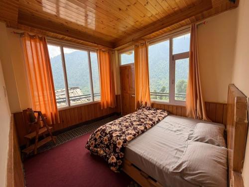 a bedroom with a bed in a room with windows at Your Slow House in Shangarh