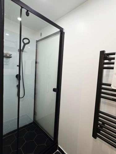 a shower with a glass door in a bathroom at La Parenthèse du Buisson Bailly - Jacuzzi, Détente et Bien être près de Provins in Choisy-en-Brie