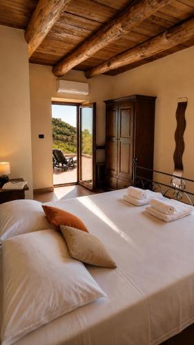 a bedroom with a large white bed with a large window at La Formica in Ascea