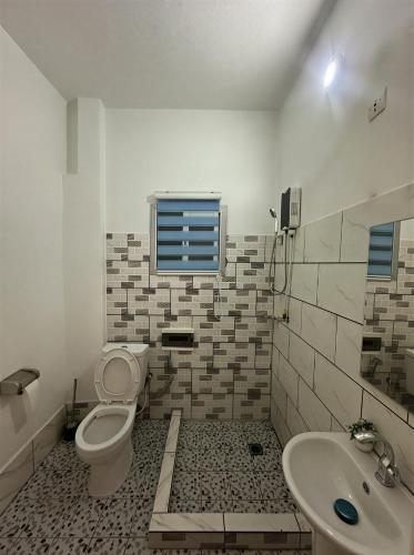 a bathroom with a toilet and a sink at Melroseplace Complex in Bonabéri