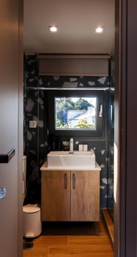 a bathroom with a sink and a tv on the wall at CASA UNO Horizon in Platamonas