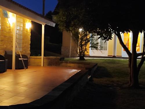 a patio at night with a tree in front of a house at VV Las Picarolas in Muros de Nalón